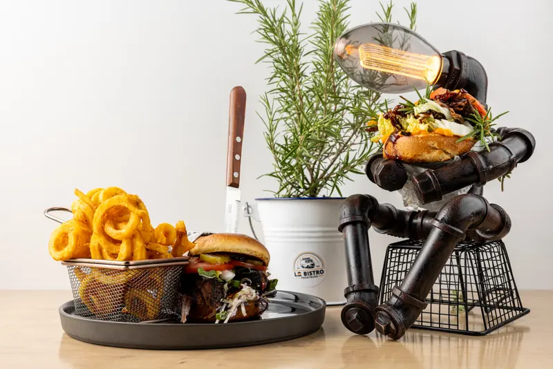 Catering-Deko von Le Bistro: Roboter-Lampe aus Eisenrohren hält einen Burger, davor TS1952 Burger und Curly Fries