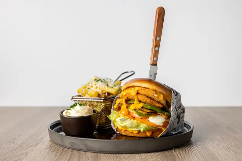 Mr. Veggie Burger mit Pommes im Drahtkorb, Dip und Messer