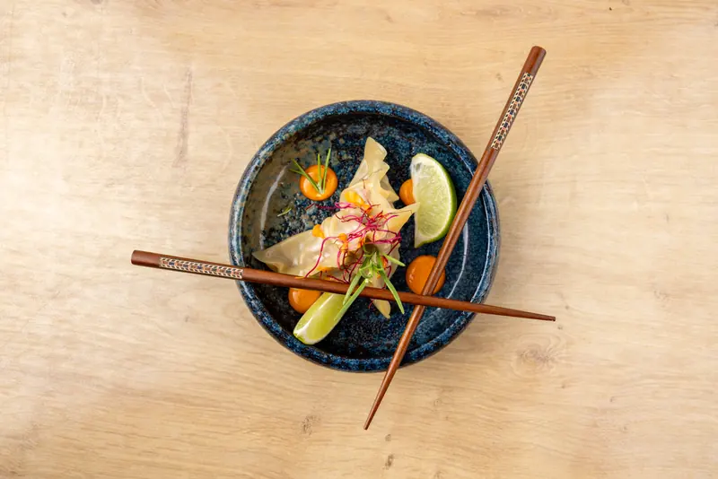Dumplings mit Huhn und Gemüse von Nazoki, mit Stäbchen und Limette