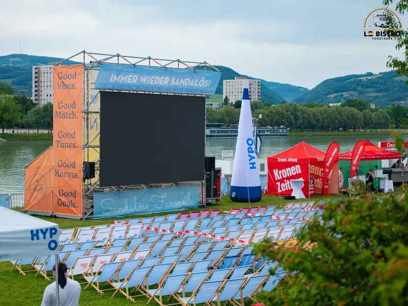 Bühne, Leinwand und Liegestühle an der Sandburg Linz