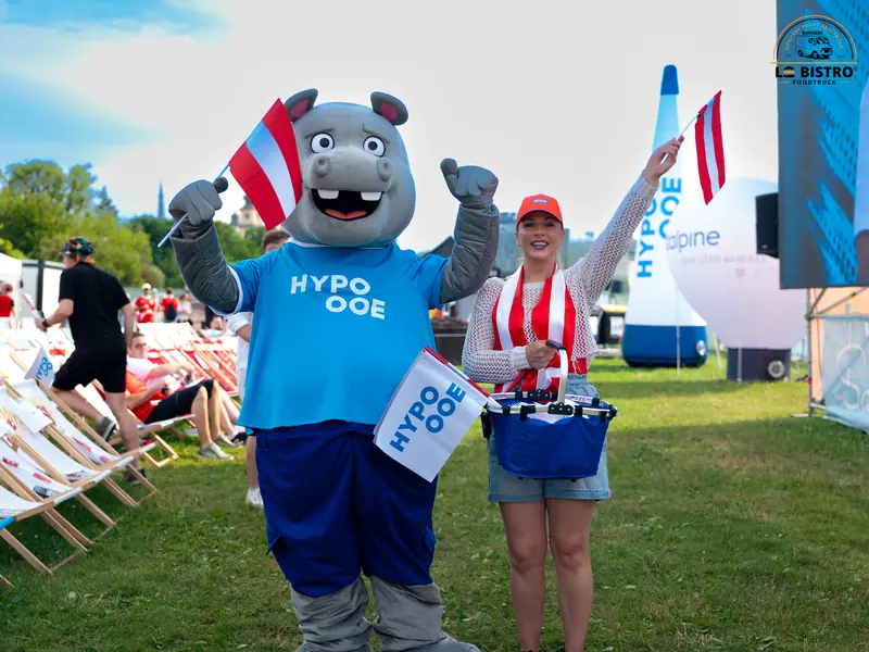 Maskottchen von HYPO Oberösterreich mit einer Besucherin, Public Viewing Sandburg Linz