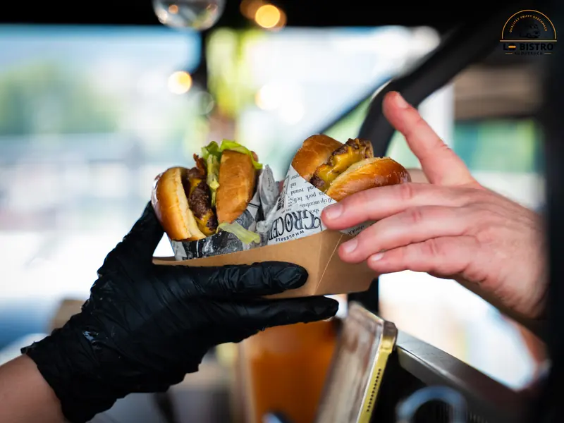 Eine Burgerschale wird aus dem Truck gereicht, Public Viewing Sandburg Linz