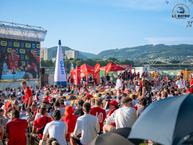 Fans vor der Leinwand an der Donau, Public Viewing Sandburg Linz