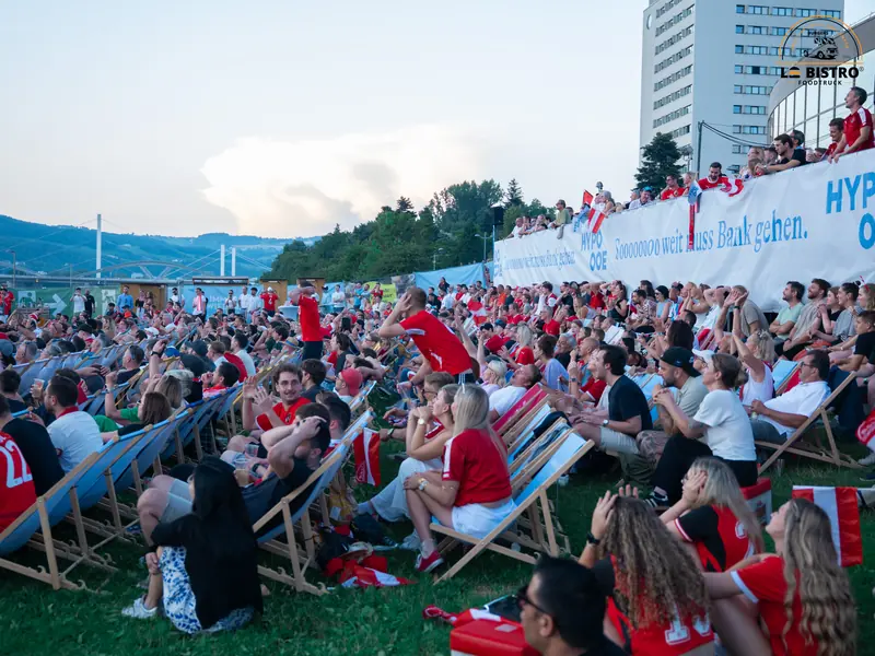 Fans vor der Leinwand mit Blick auf die Donau, Public Viewing Sandburg Linz